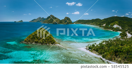 Palawan, Philippines. Las Cabanas beach with rocky mountains and village El Nido in background Palawan, Philippines. Las Cabanas beach with rocky mountains and village El Nido in background 58545525