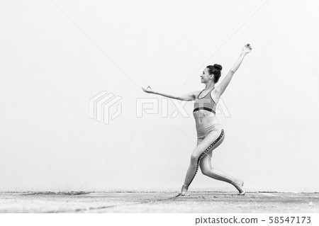 Fit sporty active girl in fashion sportswear doing yoga fitness exercise in front of gray wall Fit sporty active girl in fashion sportswear doing yoga fitness exercise in front of gray wall 58547173