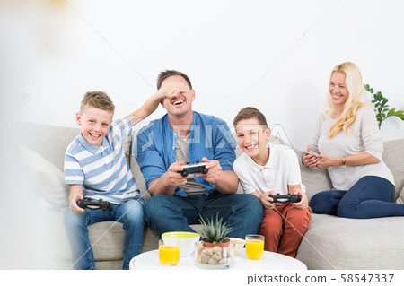 Happy young family playing videogame On TV. Happy young family playing videogame On TV. 58547337