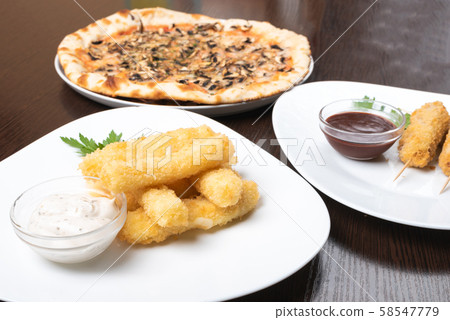 Korndog on skewers, and cheese sticks. Pizza. On the plates. 58547779