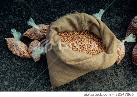 Unshelled peanuts in a straw sack on display 58547866