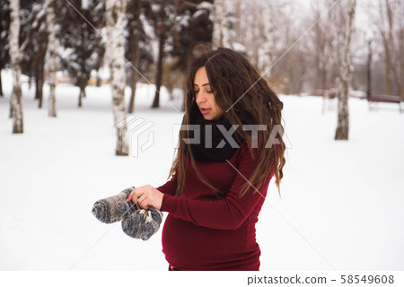 A beautiful outdoor pregnant woman portrait in snowy nature A beautiful outdoor pregnant woman portrait in snowy nature 58549608