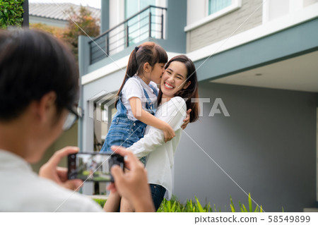 Beautiful family portrait smiling outside their Beautiful family portrait smiling outside their 58549899