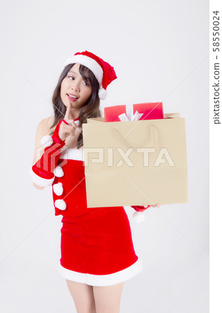 Beautiful portrait young asian woman happy and excited holding paper bag with gift box in xmas 58550024