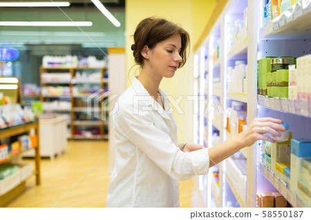 Young woman in cosmetics shop is choosing skin care cream 58550187