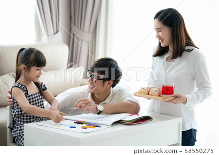 Asian family do homework togather in living room 58550275