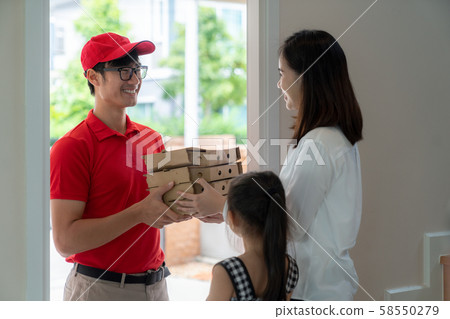 Asian woman recieve pizza box from pizza boy at Asian woman recieve pizza box from pizza boy at 58550279