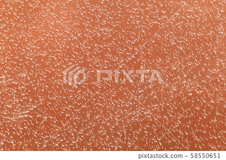 A closeup of orange painted concrete wall covered in splashes 58550651