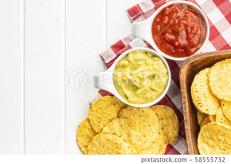 Corn nacho chips with avocado and tomato dip. 58555732