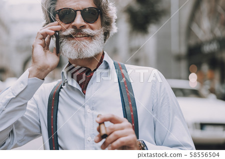 Smoking and talking on the phone outdoors stock photo 58556504