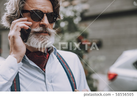 Stylish man having serious phone talk stock photo 58556505