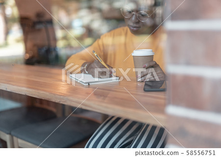 Woman making notes in cafeteria stock photo 58556751
