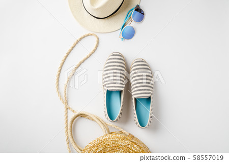 Flat lay traveler accessories on white background with straw hat, summer shoes, bag and sunglasses. 58557019