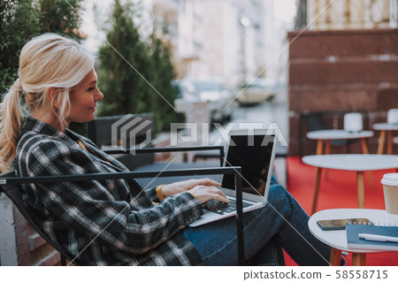 Woman working on a laptop in a cafe Woman working on a laptop in a cafe 58558715