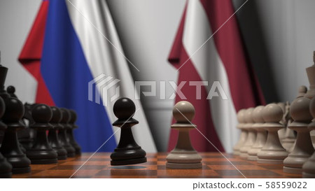 Flags of Russia and Latvia behind pawns on the chessboard. Chess game or political rivalry related 58559022