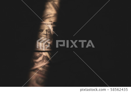 Light shines on a dollar bill 58562435