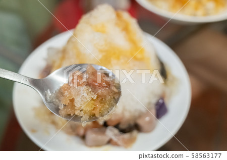 eating shaved ice with colorful dessert eating shaved ice with colorful dessert 58563177