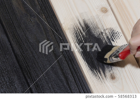 painting a wooden Board in black. black paint and 58568313