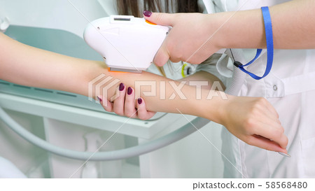 experienced therapist makes laser epilation on lady hand experienced therapist makes laser epilation on lady hand 58568480