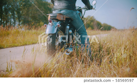 Bike with a biker is standing on the field Bike with a biker is standing on the field 58569597
