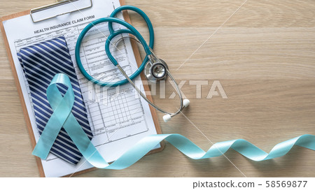 Prostate cancer blue awareness ribbon for men health concept with light blue bow color on medical health insurance claim form and stethoscope on doctor desk background Prostate cancer blue awareness ribbon for men health concept with light blue bow color on medical health insurance claim form and stethoscope on doctor desk background 58569877
