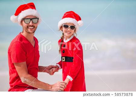 Father and daughter in Santa Hat have fun at tropical beach 58573878