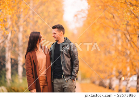 Happy family walking in autumn park on sunny fall day Happy family walking in autumn park on sunny fall day 58573986