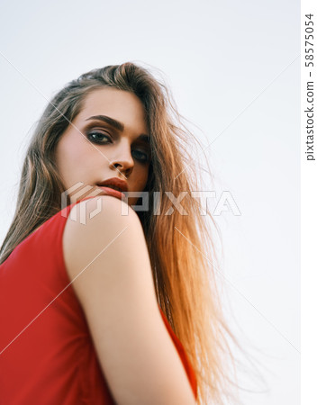 Portrait of beautiful young woman posing outdoors in summer sun 58575054
