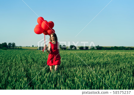 Freedom happy woman running with red balloons on green summer field Freedom happy woman running with red balloons on green summer field 58575237