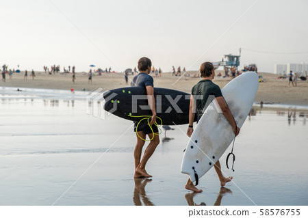 Surfers are returning from the ocean after active surfing in the waves 58576755