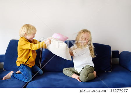 Pillow fight. Brother and sister play together. 58577077