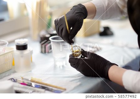 Beautician stirs the color for eyebrows Beautician stirs the color for eyebrows 58577492