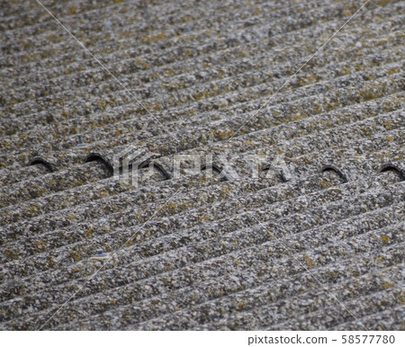 Old uralite roof, weather-deteriorated corrugated fiber cement sheets 58577780