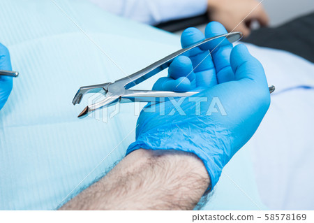 Surgery. Dentist's hand with tooth extraction Surgery. Dentist's hand with tooth extraction 58578169