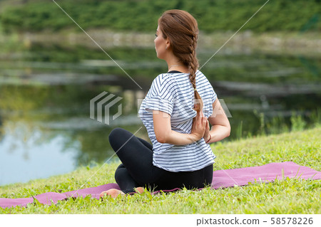 Young beautiful woman doing yoga exercise in green park. Healthy lifestyle and fitness concept. 58578226