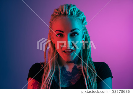 Caucasian young woman's portrait on gradient background in neon light 58578686