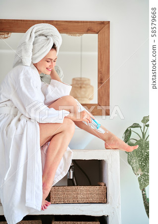 Photo on side on side of happy woman shaving her legs in bathroom. Photo on side on side of happy woman shaving her legs in bathroom. 58579668