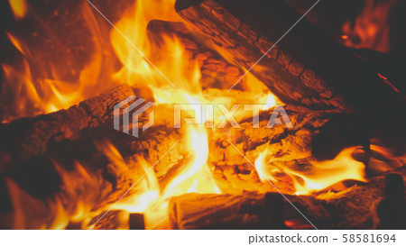 Closeup toned image of fire flames covering burning wooden logs in the fireplace at house 58581694