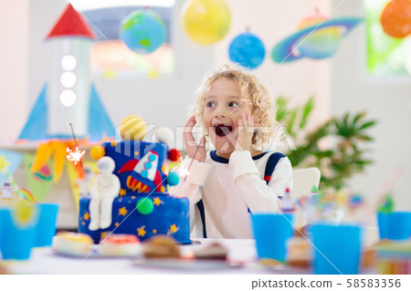 Kids space theme birthday party with cake. 58583356