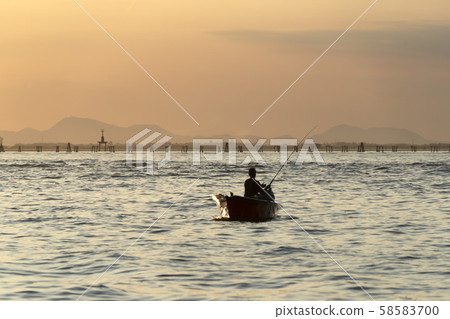 fisherman silhouette at Sunset in Venice lagoon 58583700
