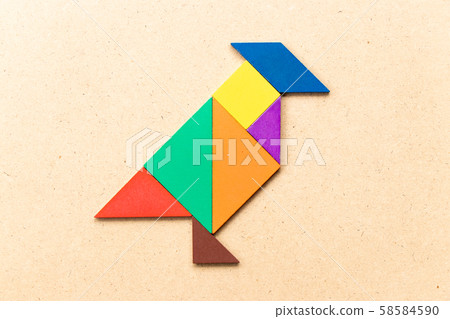Color tangram puzzle in shape on wood background Color tangram puzzle in shape on wood background 58584590