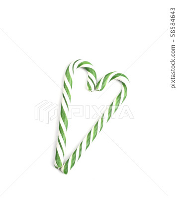 Two green caramel canes in the shape of a heart for Christmas and New Year. Two green caramel canes in the shape of a heart for Christmas and New Year. 58584643