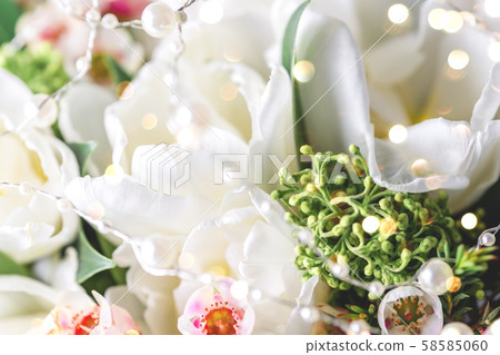 Beautiful bouquet of white tulips with green leaves and other decorative flowers close up. 58585060