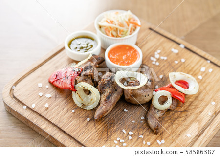 Lamb tongue kebab with Pickled cabbage and two sauces. Serving on a wooden Board. Barbecue Lamb tongue kebab with Pickled cabbage and two sauces. Serving on a wooden Board. Barbecue 58586387