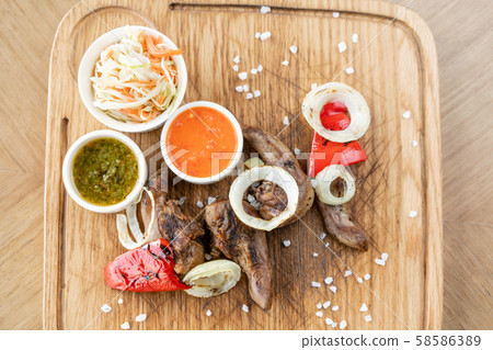 Lamb tongue kebab with Pickled cabbage and two sauces. Serving on a wooden Board. Barbecue 58586389