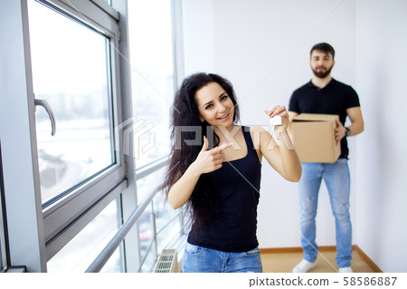 Pretty young couple moving in new home. Pretty young couple moving in new home. 58586887