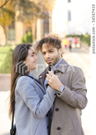 Afro american man hugging caucasian nice woman outside. 58587419