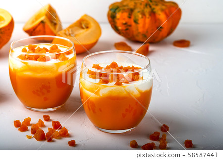 Pumpkin smoothie with yogurt and dried apricots in glasses on a white background. Autumn healthy 58587441