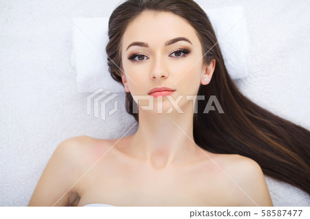 Body care. Face massage. Beautiful young woman relaxing with hand massage at beauty spa salon. 58587477