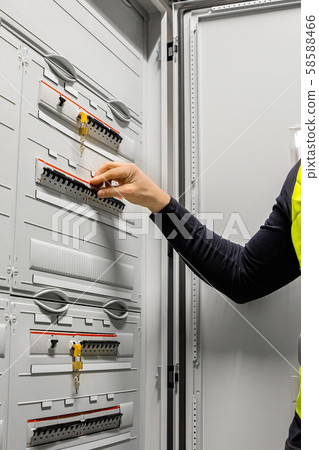 Male Electrician Checking Electric Fuse Board In Server Room 58588466